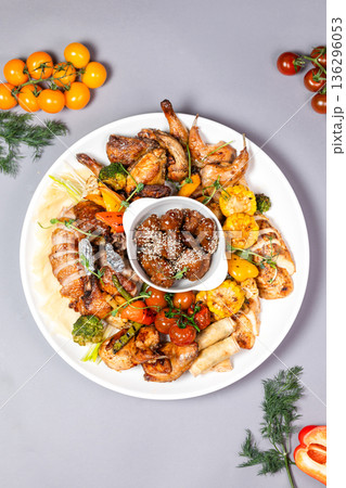 Top view of chicken platter with vegetables and sauce on white plate Top view of chicken platter with vegetables and sauce on white plate 136296053