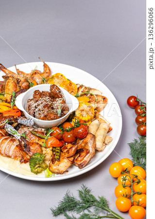 Top view of chicken platter with vegetables cheese and sauce on grey background Top view of chicken platter with vegetables cheese and sauce on grey background 136296066