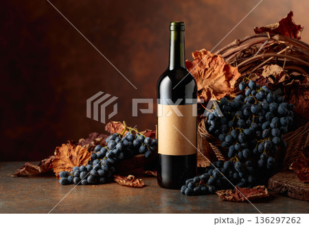 Bottle of red wine with blue grapes on a brown background. Bottle of red wine with blue grapes on a brown background. 136297262
