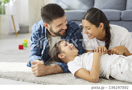 Happy family playing on carpet with laughter, hugs and love together at home Happy family playing on carpet with laughter, hugs and love together at home 136297892
