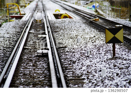 うっすら雪化粧の街中を走る鉄道線路 136298507