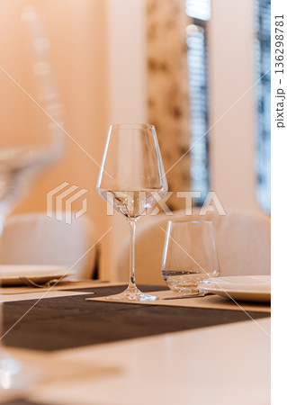 Close up of elegant glassware on modern dining table with soft bokeh and neutral tones 136298781