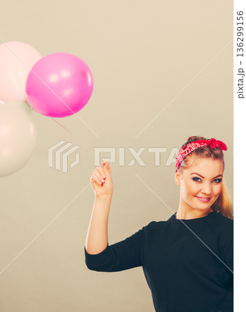 Smiling girl having fun with balloons. 136299156