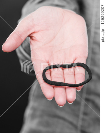 Female hand with elastic hair. Female hand with elastic hair. 136299207