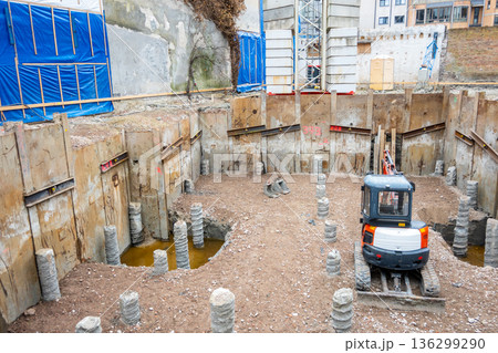 Work during the construction of a building in the city. Excavator for destruction of an old building. Work during the construction of a building in the city. Excavator for destruction of an old building. 136299290
