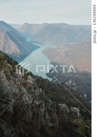 View of Perucac Lake stretching through mountain canyon from rocky viewpoint in Tara National Park, Serbia. Dramatic natural landscape with steep slopes View of Perucac Lake stretching through mountain canyon from rocky viewpoint in Tara National Park, Serbia. Dramatic natural landscape with steep slopes 136299984