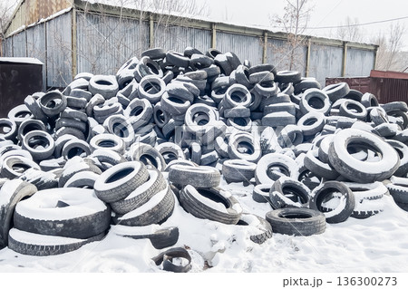 Old tires are piled at a recycling center showing how rubber is managed and disposed in relation to garbage and ecology. High quality photo 136300273