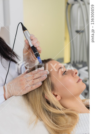 Trichologist doing woman hair regeneration procedure, dermapen microneedling, vitamin injections Trichologist doing woman hair regeneration procedure, dermapen microneedling, vitamin injections 136300859