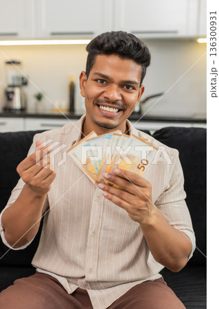 Indian man counts euro cash happy makes money gesture plans dream purchase savings bonus invest plan 136300931