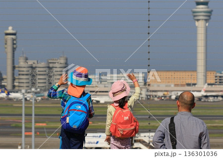 離陸する飛行機に手を振る子供　羽田空港の展望デッキの風景 136301036