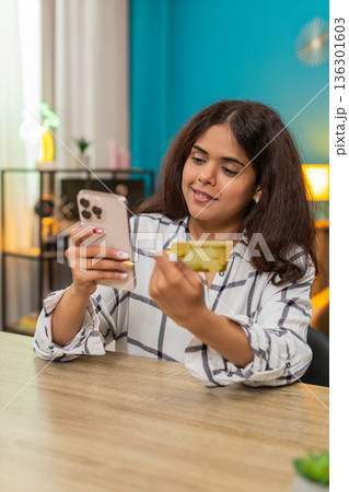 Indian woman entering credit card on smartphone reviewing payment checkout process online secure Indian woman entering credit card on smartphone reviewing payment checkout process online secure 136301603