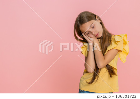 Child girl kid feeling tired gently lays head on hands and peacefully falls asleep exhausted emotion 136301722