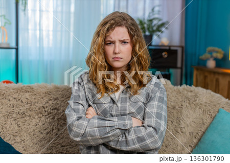 Woman sitting on sofa with crossed arms looking annoyed and displeased showing irritation and anger Woman sitting on sofa with crossed arms looking annoyed and displeased showing irritation and anger 136301790