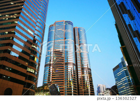 Skyscrapers tower bright glass exteriors sunlight sunset. Facade office buildings. 136302327