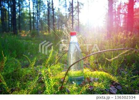Plastic bottle with fresh drinking water on forest background. Plastic bottle with fresh drinking water on forest background. 136302334