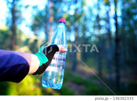 Plastic bottle with fresh drinking water on forest background. Plastic bottle with fresh drinking water on forest background. 136302335