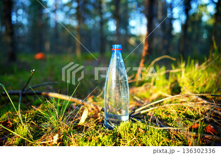 Plastic bottle with fresh drinking water on forest background. 136302336