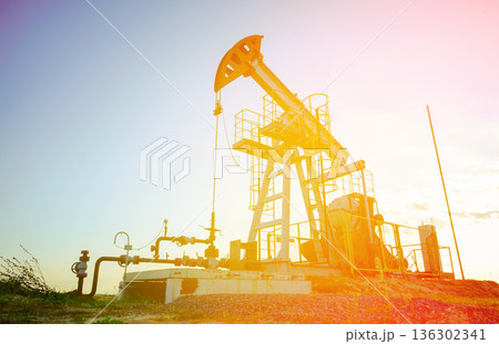Pumpjack in oil well of oil field on sunrise in Industrial crude area. Crude pump jack oil field Pumpjack in oil well of oil field on sunrise in Industrial crude area. Crude pump jack oil field 136302341