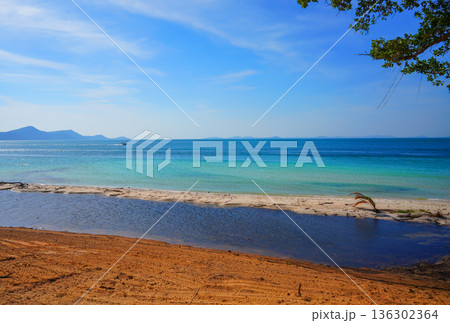Bright blue sea with white sand beach on sunny day. Speed boat at Mountains distant on blue sky 136302364