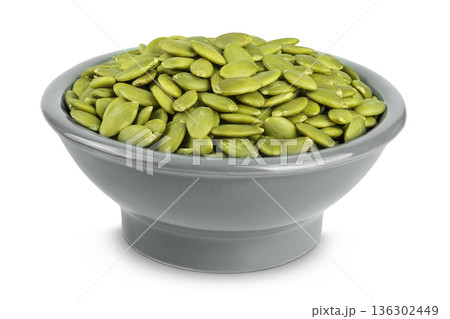 Peeled pumpkin seeds in ceramic bowl isolated on white background Peeled pumpkin seeds in ceramic bowl isolated on white background 136302449