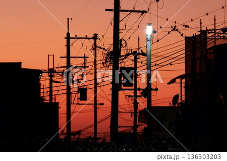 東大阪市東花園付近の電線が絡み合う夕焼け風景 東大阪市東花園付近の電線が絡み合う夕焼け風景 136303203