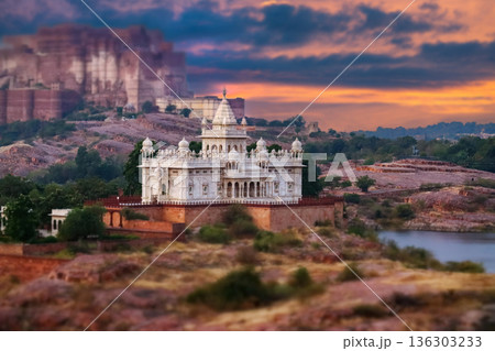 Scenic view of the white marble Jaswant Thada cenotaph in Jodhpur, Rajasthan, surrounded by rocky hills and a tranquil lake at sunset. Scenic view of the white marble Jaswant Thada cenotaph in Jodhpur, Rajasthan, surrounded by rocky hills and a tranquil lake at sunset. 136303233