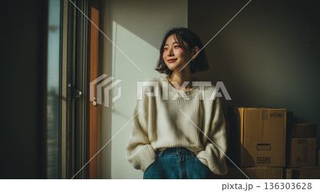 /* 引っ越し後の新居で新生活を迎える女性の落ち着いた室内シーン */ 136303628