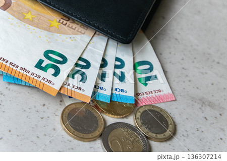 Black partmone with euro money. Coins and bills in leather wallet for commerce concept. 136307214