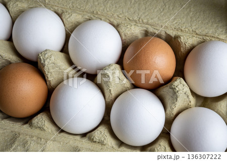White and brown fresh eggs. Nature background. Chicken egg in carton box for cooking healthy food. Bio organic eggs on the farm. White and brown fresh eggs. Nature background. Chicken egg in carton box for cooking healthy food. Bio organic eggs on the farm. 136307222