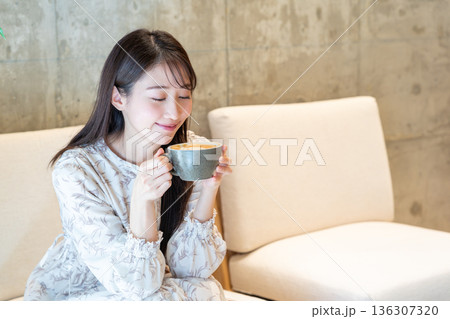 カフェでカフェラテを飲む女性 136307320