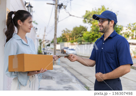 Delivery express courier young man use giving boxes or Food to woman customer  at front home.  136307498