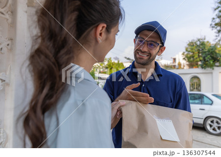 Delivery express courier young man use giving boxes or Food to woman customer  at front home.  136307544