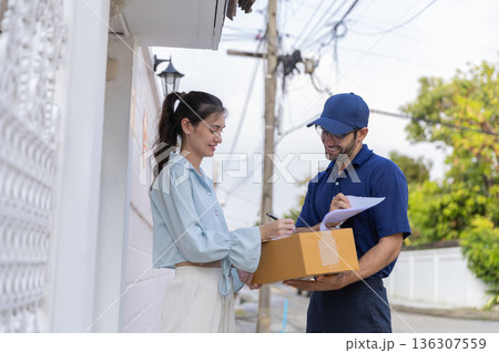 Delivery express courier young man use giving boxes or Food to woman customer at front home. Delivery express courier young man use giving boxes or Food to woman customer at front home. 136307559