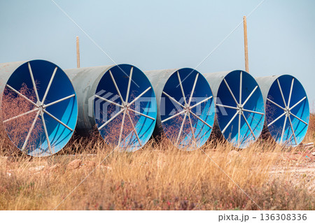 Steel Large  diameter pipes are stacked in an industrial factory at construction site.  136308336