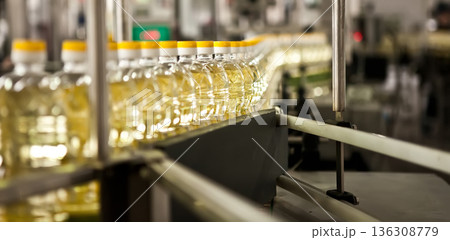 Automated production line bottling golden sunflower oil in a modern food manufacturing plant 136308779