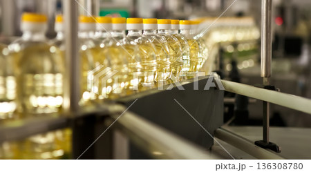 Automated production line bottling golden sunflower oil in a modern food manufacturing plant 136308780