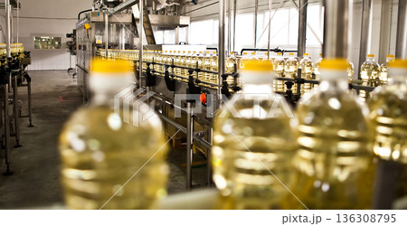 Automated production line bottling golden sunflower oil in a modern food manufacturing plant Automated production line bottling golden sunflower oil in a modern food manufacturing plant 136308795