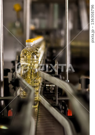 Automated production line bottling golden sunflower oil in a modern food manufacturing plant Automated production line bottling golden sunflower oil in a modern food manufacturing plant 136308796