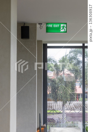 Green emergency exit sign showing the way to escape. Fire exit in the building. 136308917