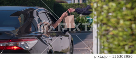 Hand Man in car receiving coffee in drive thru fast food restaurant. Hand Man in car receiving coffee in drive thru fast food restaurant. 136308980