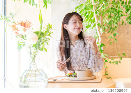カフェでランチを食べている若い女性 カフェでランチを食べている若い女性 136308995
