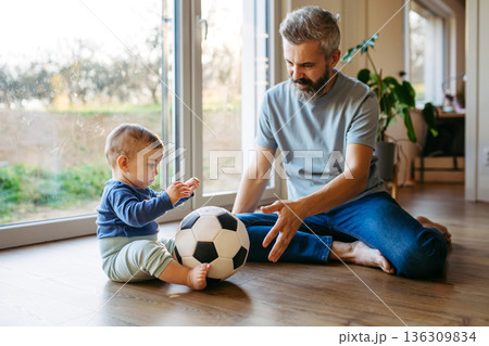 Father playing with little son with ball. Father playing with little son with ball. 136309834