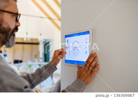 Man using smart home control panel. 136309867