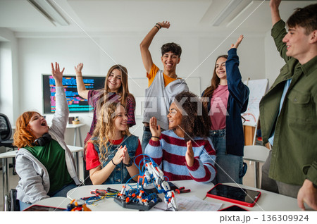 Teen students working as a team on robotics project in classroom. 136309924