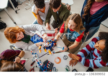 Teen students working as a team on robotics project in classroom. 136309932