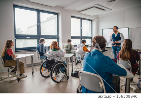 Inclusive classroom scene with student using wheelchair. Inclusive classroom scene with student using wheelchair. 136309940