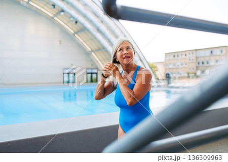 Senior woman preparing for swim t. raining to stay healthy and active Senior woman preparing for swim t. raining to stay healthy and active 136309963