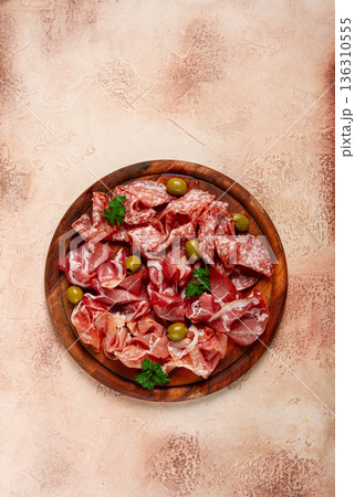 Assortment , sliced meat appetizer, prosciutto, salami and ham, with olives, on a wooden board, breakfast, top view, close-up, no people, 136310555