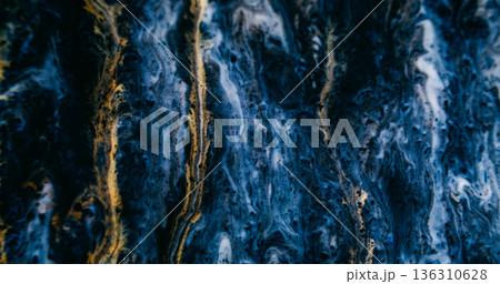 Paint flow. Dark art texture. Golden yellow trickles spill on black blue acrylic fluid. Grunge pigment color mix blur abstract background. 136310628