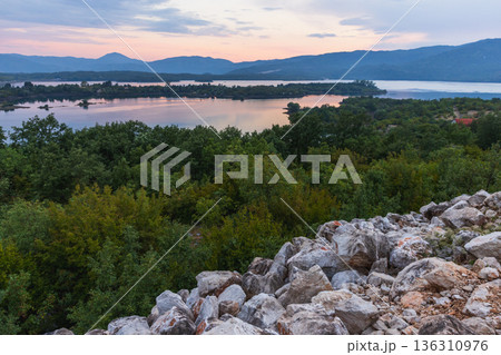 A tranquil landscape featuring a rocky foreground A tranquil landscape featuring a rocky foreground 136310976